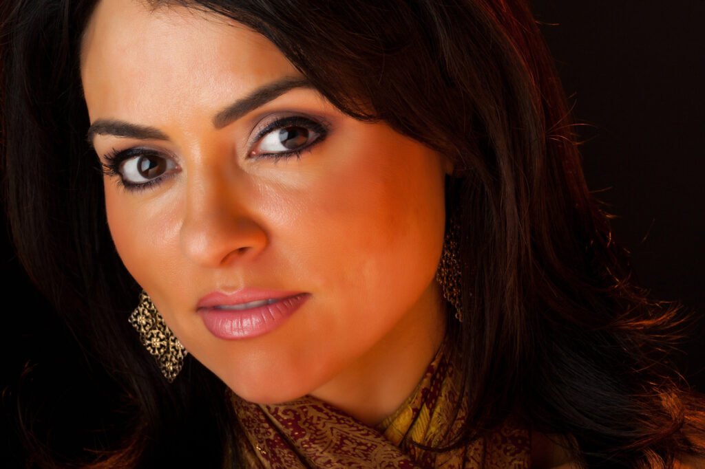 Close-up beauty portrait with warm makeup and gold earrings