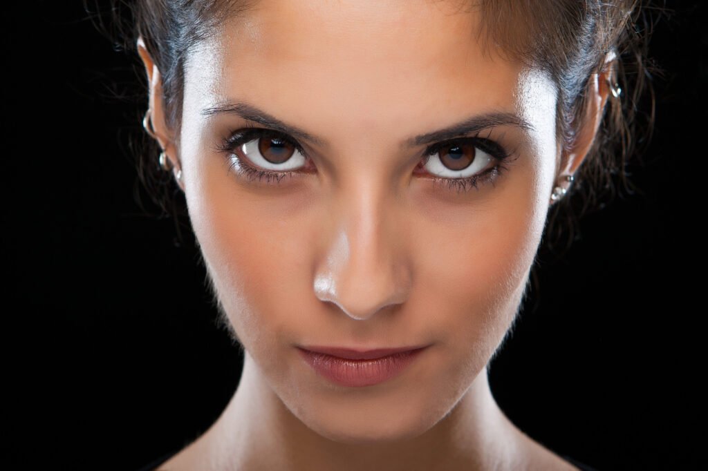 Close-up portrait emphasizing eyes and studio makeup