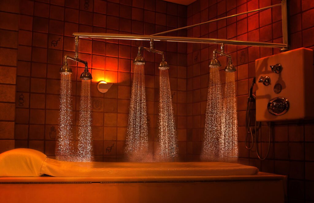 Spa bathing area with a waterfall and amber lighting