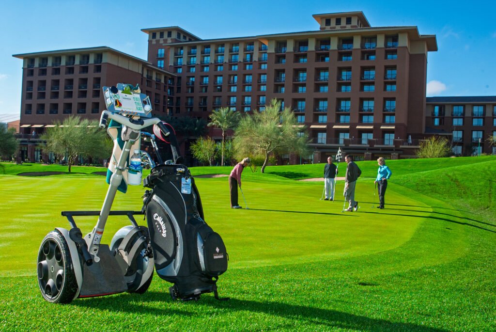 Golf trolley and bag on a green outside a resort