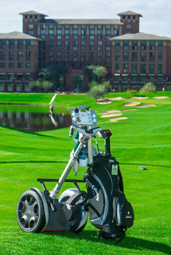 Golf trolley on a manicured lawn beside a resort building