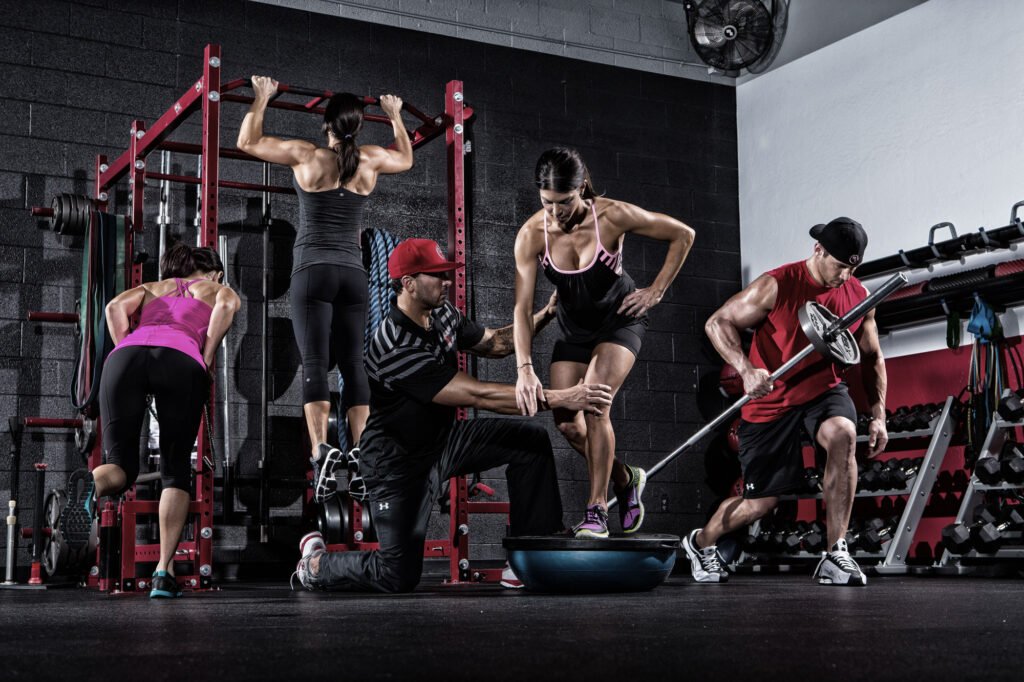 Group of athletes training with weights and gym equipment