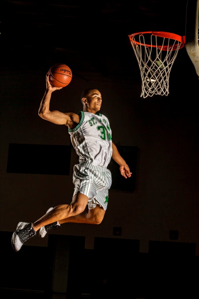 Basketball player in a striped uniform jumping toward the hoop