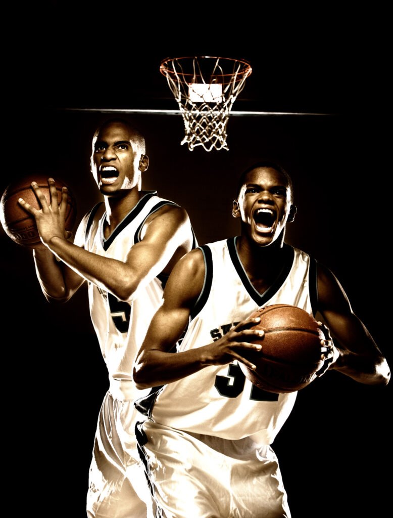 Two basketball players posing beneath a hoop