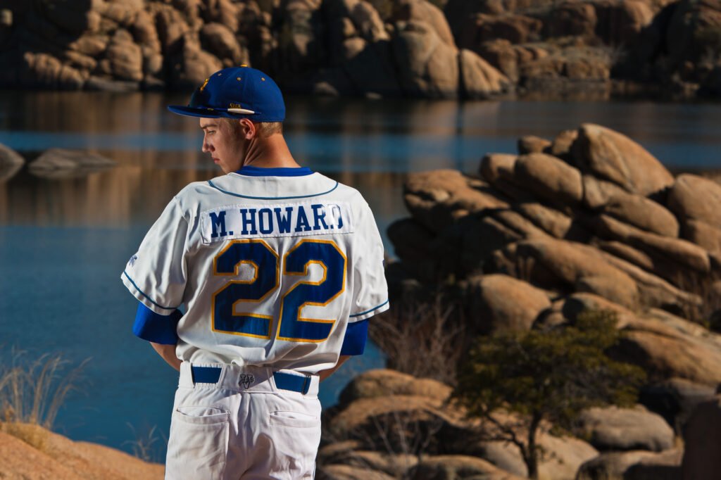Baseball player wearing number 22 beside a rocky lake