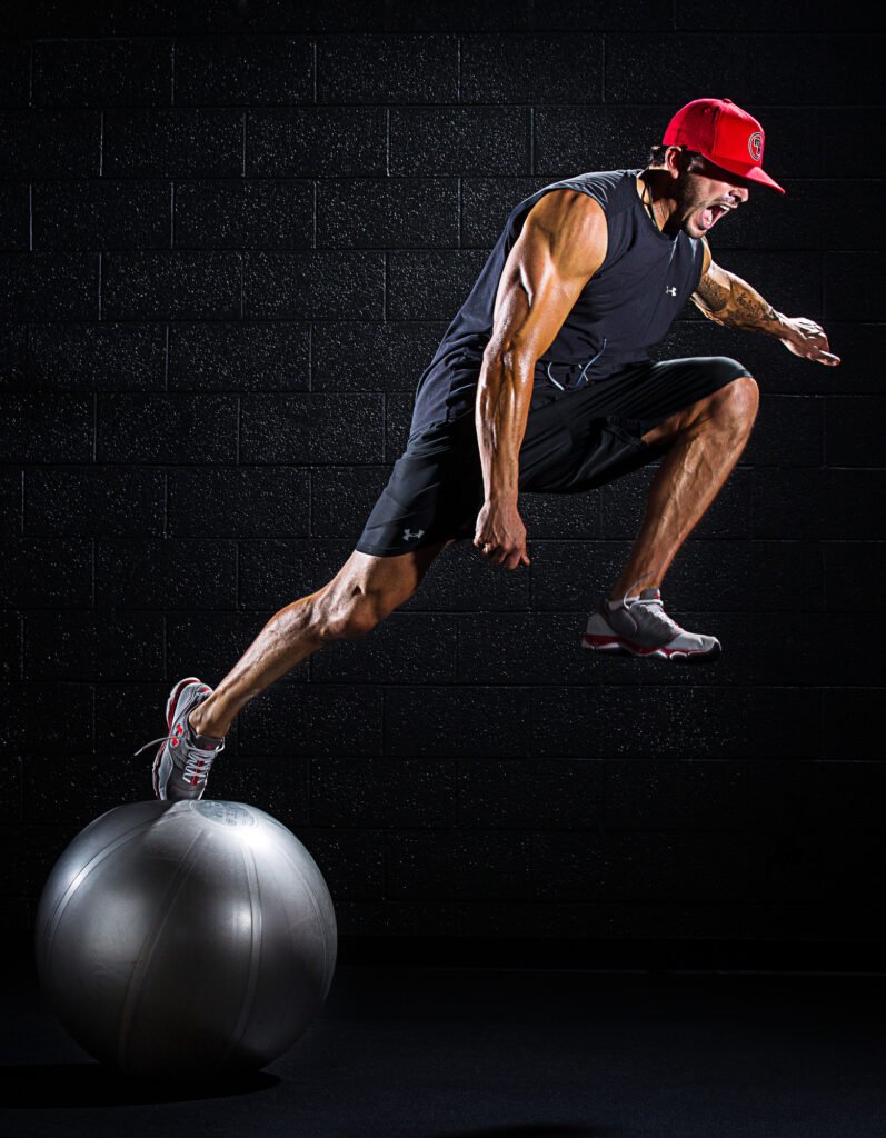 Athlete balancing on an exercise ball in a dark studio